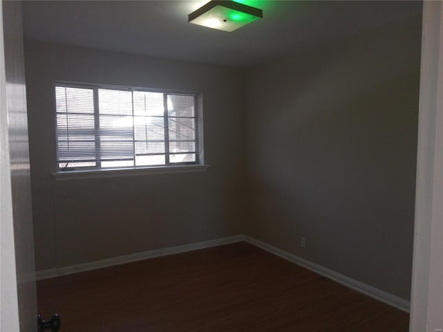 unfurnished room with dark wood-type flooring