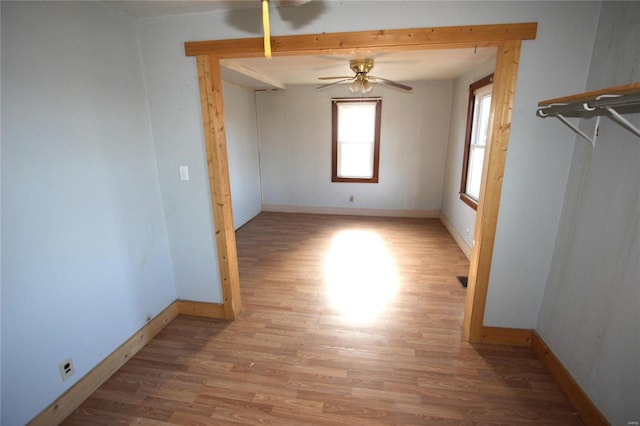 empty room with ceiling fan and light wood-type flooring