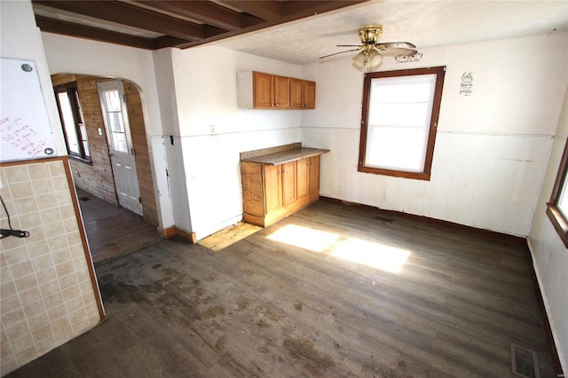 kitchen featuring beam ceiling, ceiling fan, a healthy amount of sunlight, and dark hardwood / wood-style flooring