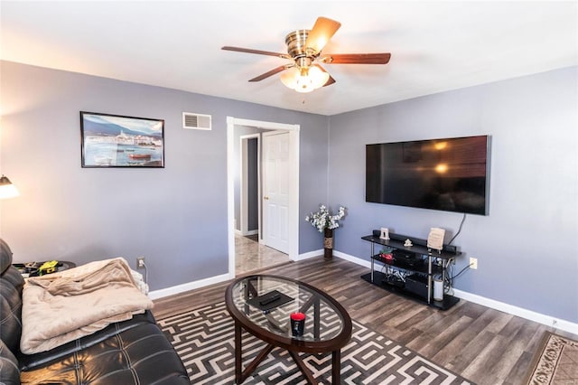 living room featuring dark wood-type flooring and ceiling fan