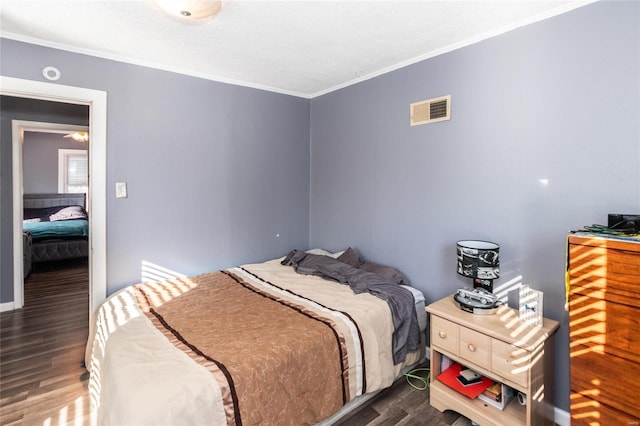 bedroom featuring crown molding and dark hardwood / wood-style floors