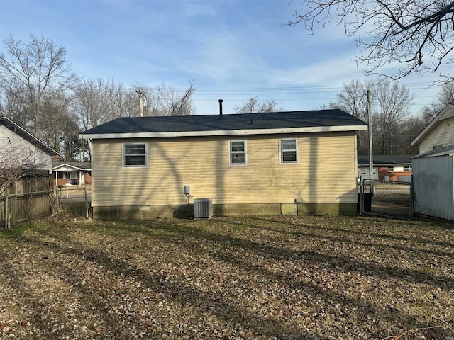 back of house featuring a yard and central AC