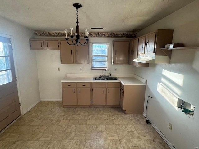 kitchen with an inviting chandelier, a healthy amount of sunlight, decorative light fixtures, and sink