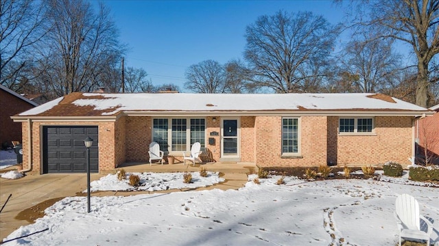 single story home featuring an attached garage and brick siding