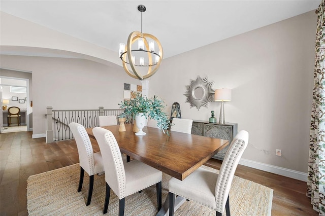 dining space with dark hardwood / wood-style flooring and a notable chandelier