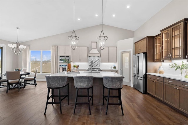 kitchen featuring sink, appliances with stainless steel finishes, an inviting chandelier, hanging light fixtures, and a kitchen bar