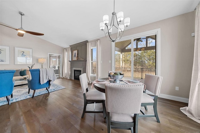 dining area with dark hardwood / wood-style flooring, ceiling fan with notable chandelier, and vaulted ceiling