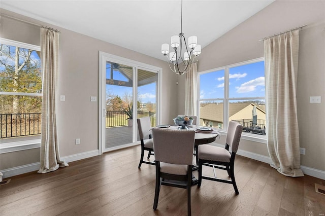 dining space with vaulted ceiling, dark hardwood / wood-style floors, and a chandelier