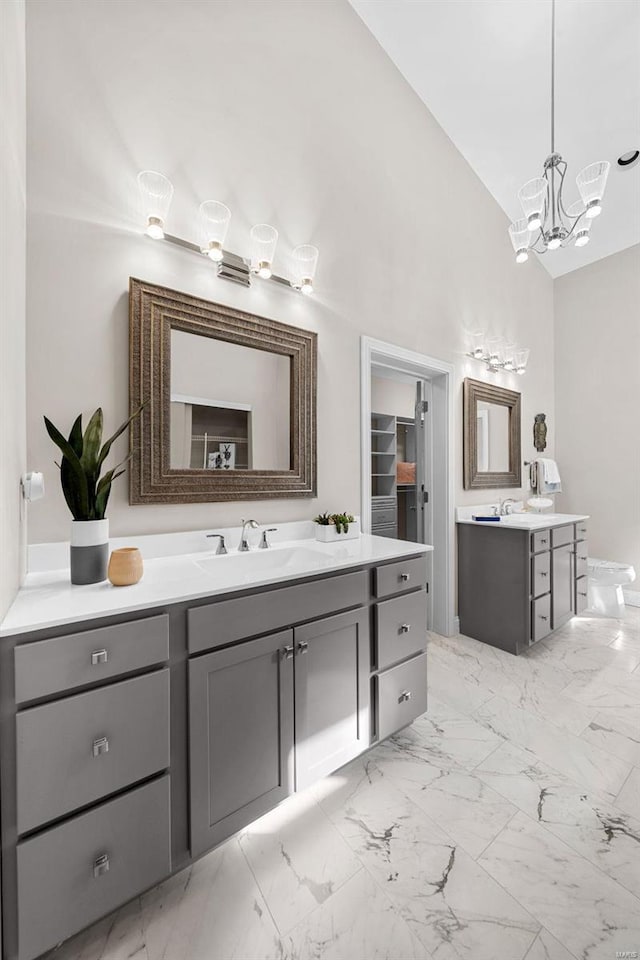 bathroom with vanity, high vaulted ceiling, and an inviting chandelier