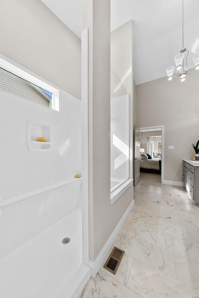 bathroom featuring lofted ceiling and a notable chandelier