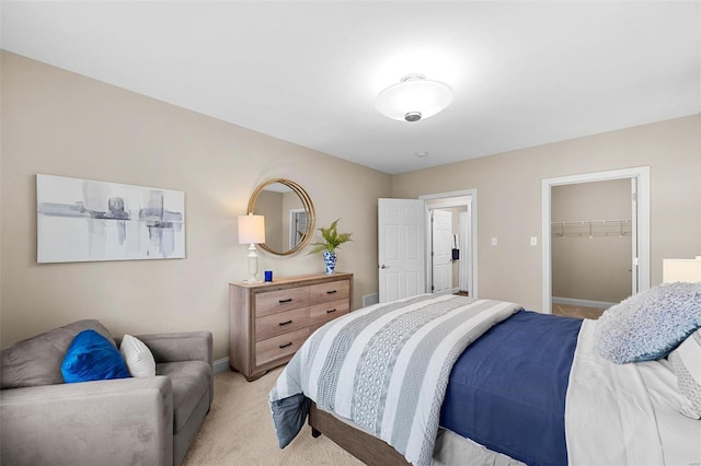 carpeted bedroom with a walk in closet and a closet