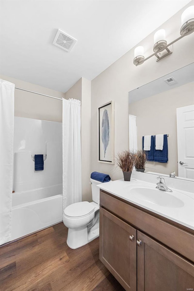 full bathroom featuring wood-type flooring, toilet, shower / tub combo, and vanity