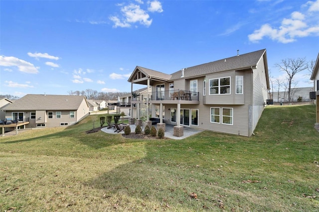 rear view of property featuring a yard, a patio area, and a balcony