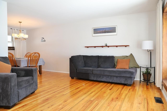 living room featuring a chandelier and light hardwood / wood-style flooring