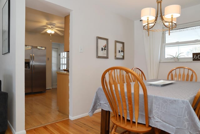 dining room featuring hardwood / wood-style flooring and ceiling fan with notable chandelier