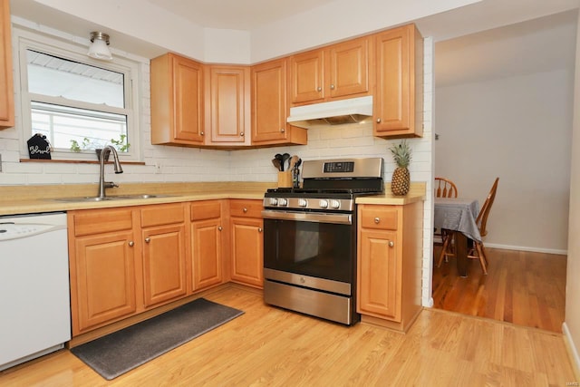 kitchen featuring sink, gas stove, light hardwood / wood-style flooring, dishwasher, and backsplash