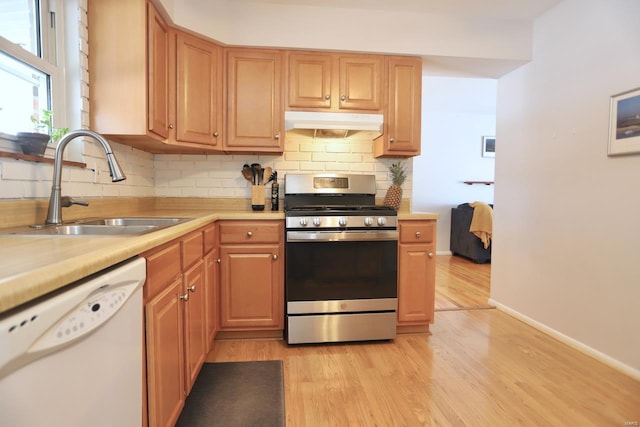 kitchen with tasteful backsplash, dishwasher, sink, light hardwood / wood-style floors, and gas stove