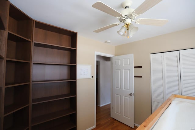 unfurnished bedroom with ceiling fan, dark hardwood / wood-style flooring, and a closet