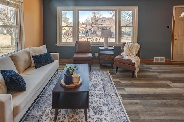 living room featuring a healthy amount of sunlight and dark wood-type flooring