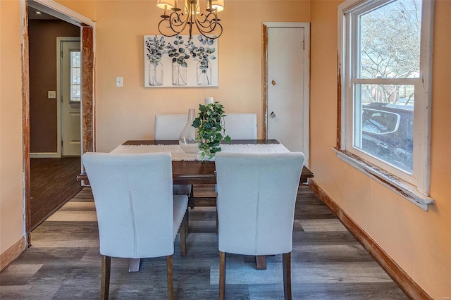 dining room with dark hardwood / wood-style flooring and a chandelier