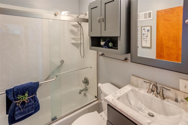 full bathroom with vanity, bath / shower combo with glass door, and toilet