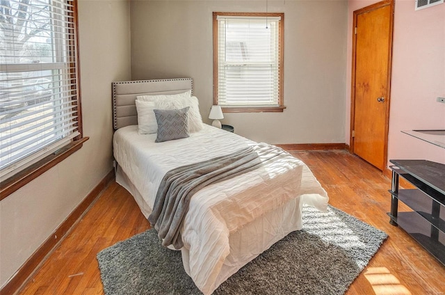 bedroom with wood-type flooring and multiple windows