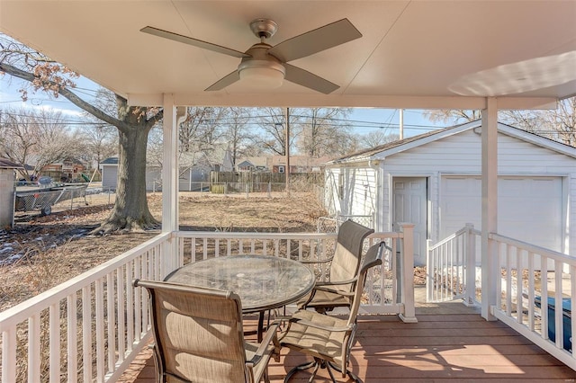 wooden terrace with a garage, an outbuilding, and ceiling fan