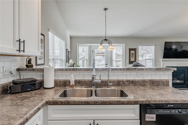 kitchen with sink, dishwasher, white cabinetry, decorative backsplash, and decorative light fixtures