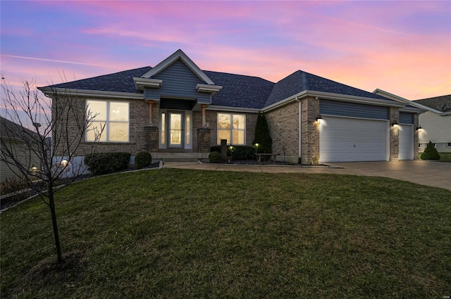 view of front of property featuring a garage and a lawn