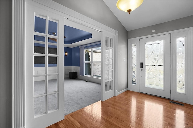 entrance foyer with hardwood / wood-style flooring, lofted ceiling, and french doors