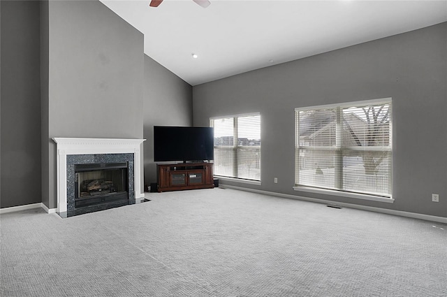 unfurnished living room with ceiling fan, carpet flooring, a fireplace, and high vaulted ceiling