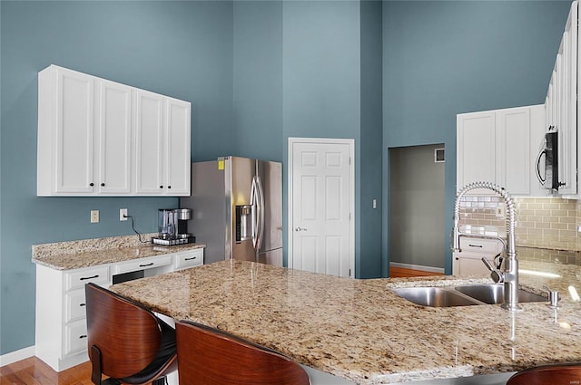 kitchen with light stone countertops, a breakfast bar, kitchen peninsula, and appliances with stainless steel finishes