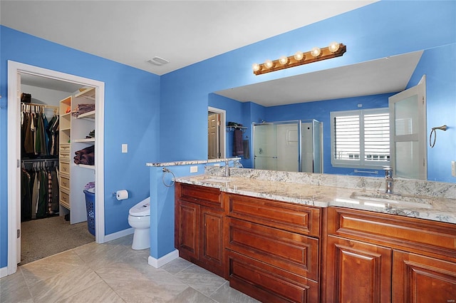 bathroom featuring vanity, toilet, and a shower with door