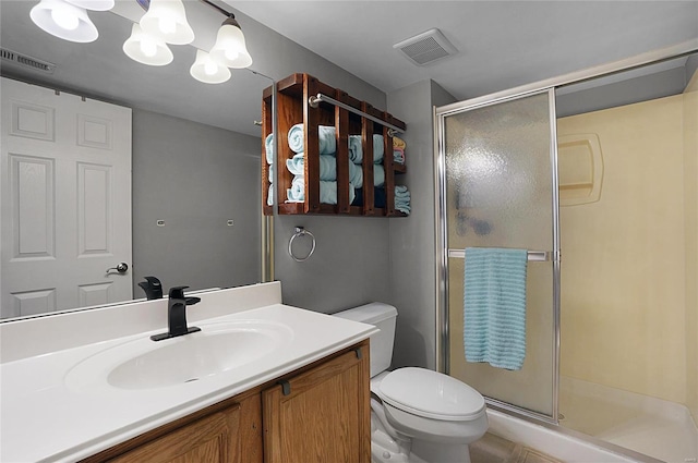 bathroom with walk in shower, vanity, and toilet