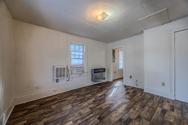 spare room featuring cooling unit, dark hardwood / wood-style floors, and heating unit