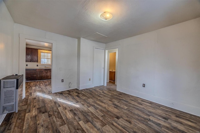 interior space with dark hardwood / wood-style flooring, sink, and heating unit