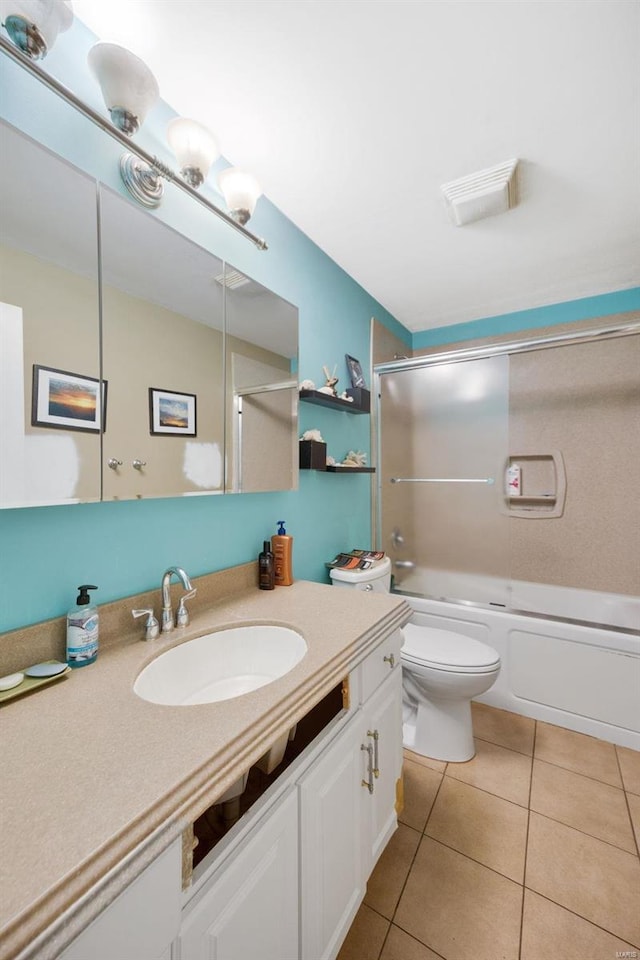 bathroom featuring tile patterned flooring, toilet, vanity, visible vents, and washtub / shower combination