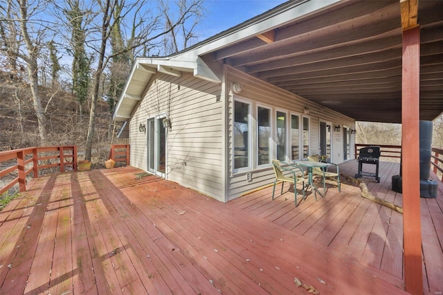 wooden deck with outdoor dining area and grilling area