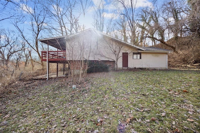 view of home's exterior with a deck and a yard