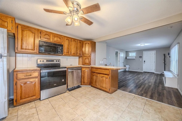 kitchen featuring light tile patterned flooring, sink, ceiling fan, kitchen peninsula, and stainless steel appliances