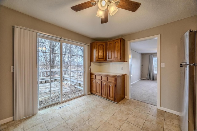 kitchen with stainless steel refrigerator, ceiling fan, and light tile patterned flooring