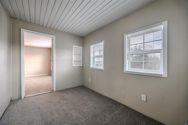 spare room with carpet flooring and wooden ceiling