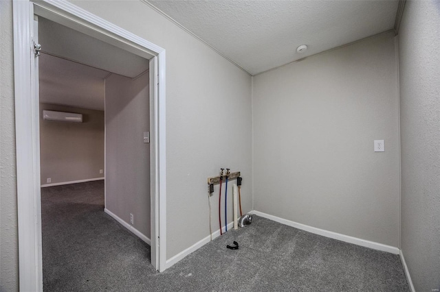 washroom featuring dark carpet, an AC wall unit, and a textured ceiling