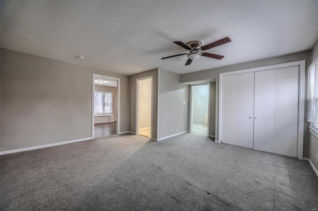 unfurnished bedroom featuring ceiling fan, light colored carpet, a closet, and a textured ceiling