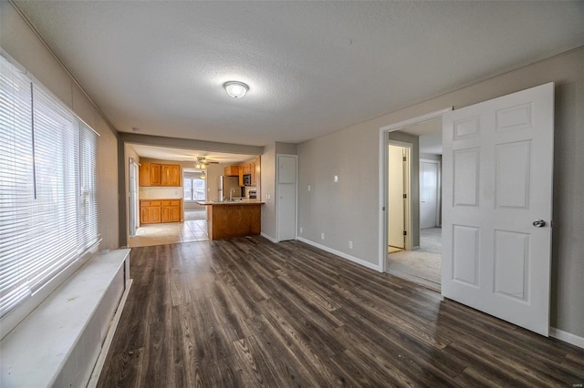 unfurnished living room featuring dark wood-type flooring and a textured ceiling