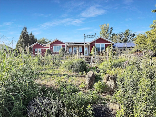 rear view of house featuring solar panels