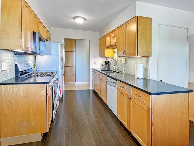 kitchen featuring dark wood-type flooring, appliances with stainless steel finishes, sink, and backsplash