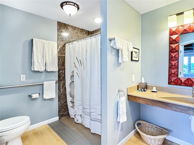 bathroom featuring toilet, sink, and a shower with shower curtain