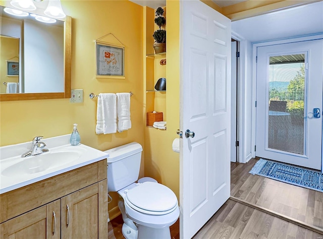 bathroom with vanity, toilet, and hardwood / wood-style floors