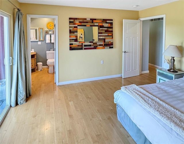 bedroom with light wood-type flooring and ensuite bath